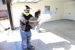 man throwing polyurea chip coating to creat aesthetic floor