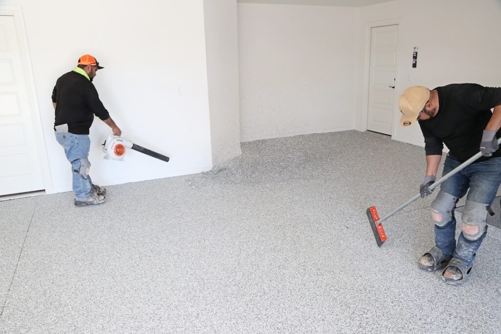 two men applying the polyurea concrete coating to a garage floor